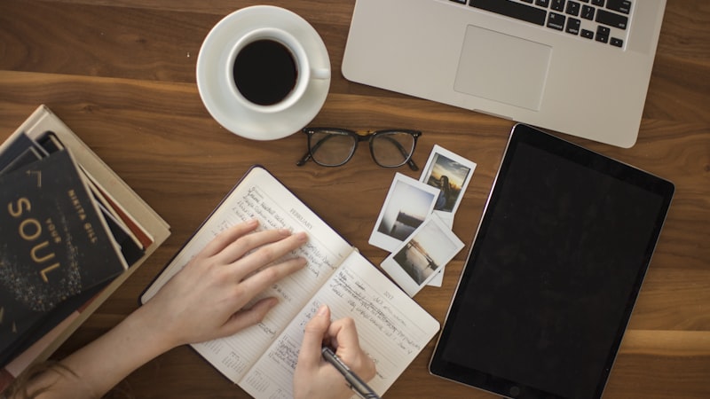 Person studying at a desk with books and a laptop